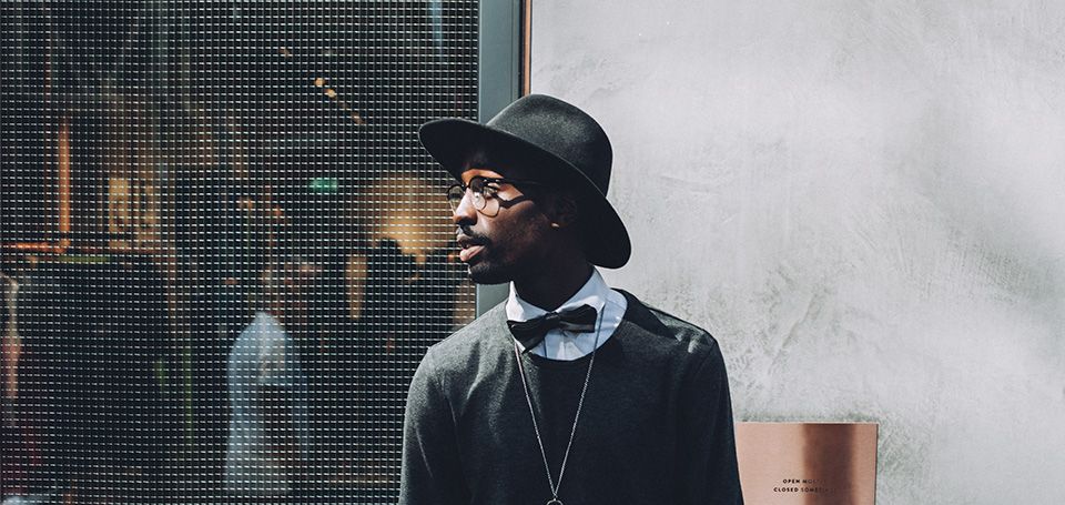 Well dressed male standing in front of a building